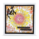 A square handmade greeting card featuring a colorful retro floral design with yellow, pink, and orange sunburst patterns, black abstract scribbles, and a black text strip that reads, 'my wallet is like an onion, opening it makes me cry.' The card is presented at a slight angle against a clean white background.