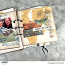 Open scrapbook with travel-themed pages on a gray surface