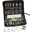 ChimooGo knitting needle kit in a black zippered carrying case, shown open with multiple orange-handled needles, a metal gauge, colorful ring binders, cables, and small accessories on a white background.