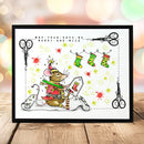 A framed Christmas-themed illustration featuring a mouse dressed as Santa, scissors, stockings, stars, and the text 'MAY YOUR DAYS BE MERRY AND MICE,' displayed on a wooden surface with a blurred festive background.