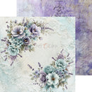 A decorative scrapbook paper sheet with floral corner arrangements in soft lavender, blue, and white, layered over a textured vintage-style background. A second matching patterned sheet is partially visible behind it.