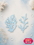 Two light blue coral-shaped craft cutouts displayed on a textured white and light blue background with decorative seashells, dried flowers, and clear water droplets. A pink 'CRAFT & YOU' logo is visible in the bottom right corner.
