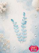 Two light blue watercolor-style botanical leaf stems arranged vertically on a textured white and pale blue background with decorative seashell, dried flowers, and clear water droplets. A pink 'CRAFT & YOU' logo appears in the bottom right corner.