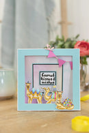 Decorative frame with camel illustrations and text on a table.