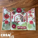 A handmade Christmas-themed triptych card displayed on a wooden surface. The card features three vertical panels decorated with red poinsettias, green pine branches, and a central floral arch.