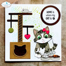 A square handmade greeting card featuring a cartoon tabby cat with green eyes and a pink bow, sitting beside a cat tree, fish, food bowl, and a circular sign that reads 'HOME is where my CAT is'. The card is photographed on a textured beige surface, with an 'Elizabeth craft designs' watermark in the top-left corner.