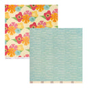 Two patterned scrapbook paper sheets shown on a white background. The top-left sheet has a retro floral pattern with pink, orange, yellow, and blue flowers on a cream grid background.