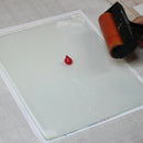 Red stamp pad on a white surface with a clear stamp