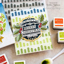 A handmade Christmas greeting card with a layered die-cut design, surrounded by Gina K. Designs ink pads and stamping tools on a neutral fabric background.