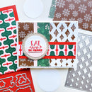 A handmade Christmas-themed greeting card with layered holiday patterns in green, red, brown, and white, featuring a central circular die-cut label that reads 'EAT drink? BE MERRY.' Surrounding the card are coordinating patterned paper sheets, a metal die, and white circular paper doilies on a light background.