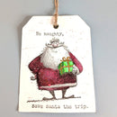 A white Christmas gift tag with a hanging twine string, featuring a hand-drawn illustration of Santa Claus holding a green gift box. The text reads 'Be naughty, Save santa the trip.