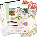 Card making kit with floral designs and papers on a white background