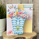 Greeting card with striped socks and flowers on a wooden surface