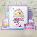 A handmade layered birthday card set with a central tiered cake card, smaller side cards reading 'Special Day' and 'Happy Birthday,' bows, strawberries, and pastel purple decorative elements, photographed on a light surface against a white textured wall.