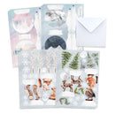 A set of Christmas-themed sticker sheets and an envelope on a white background. The sticker sheets feature winter forest illustrations including snowy trees, pine trees, snowflakes, a moon, and woodland animals such as deer, foxes, a squirrel, and a bird.