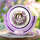 Decorative card with a wreath design featuring purple flowers and a bow, set against a blurred floral background.
