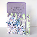 A handmade layered card with a purple patterned background, featuring 3D paper flowers in pastel blue, lavender, and white, and a decorative picket fence design. The card reads 'SENDING YOU special THOUGHTS AND BIRTHDAY WISHES to all'.