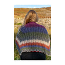 Person wearing a colorful knitted shawl in a natural setting