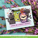 A handmade Halloween greeting card featuring two gray cats, a green cauldron, a purple potion bottle with a bat, and a pink banner reading 'Wishing you a purrfect Halloween.' The card is styled on a teal textured surface with purple flowers around it.