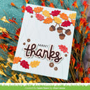 A handmade autumn-themed greeting card with 'MANY thanks' in script, decorated with layered red, orange, and yellow leaves and brown acorns, displayed on a teal textured background with dried orange leaves.