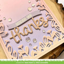 Card with 'sending you thanks' text and decorative elements on a wooden surface.