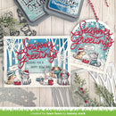 A handmade holiday card and matching hanging ornament displayed on a whitewashed wood surface with crafting tools and greenery around it. The card and ornament feature the words “Season’s Greetings” in red script, snowy trees in blue and white, and illustrated dogs and cats wearing winter hats and scarves.