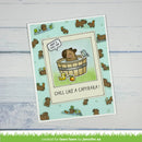 A square greeting card featuring a cartoon capybara in a wooden bath tub with the text 'CHILL LIKE A CAPYBARA!' and a speech bubble reading 'HAVE A CUTE DAY!', shown on a whitewashed wood background.