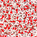 A dense pile of small Santa Claus-themed decorative pieces, mostly white with red triangular hats and black facial features, filling the frame.