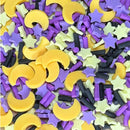 A close-up of small decorative candy-like pieces in yellow crescent moon shapes, purple star shapes, pale yellow star shapes, purple cylindrical pieces, and black cylindrical sprinkles mixed together.