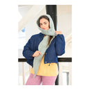 Woman wearing a blue jacket and pink pants with a long gray Hooded Scarf made from Lion Brand Feels Like Bliss Yarn.