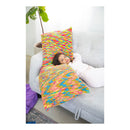Person lying on a couch with a colorful woven blanket and pillow