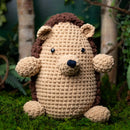 Crocheted hedgehog toy on a grassy background