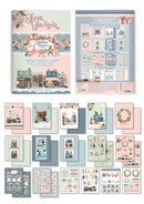 A Christmas-themed scrapbooking journaling kit with multiple coordinating sheets, stickers, and embellishments displayed on a white background. The set includes a journal cover, backing paper, and various decorative cards, washi tapes, and stickers in pastel holiday colors.