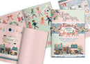 A Christmas-themed 'Junk Journal' and matching paper sheets displayed in a flat-lay arrangement. The pages feature whimsical vintage illustrations of Santa Claus, children skating, stockings, and a festive village scene, set against pastel pink and mint green backgrounds with subtle glitter textures.