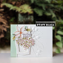 A handmade greeting card featuring a white embossed floral design, a layered white poinsettia with green and red accents, and the text 'beauty, peace & joy to you!'. The card is displayed on a white surface with a blurred green background, and a 'Penny Black' brand label is visible near the top right.