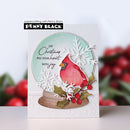 A handmade Christmas greeting card featuring a red cardinal, white snowflakes, green holly leaves, and red berries, with the text 'LET Christmas FILL YOUR heart WITH joy'. The card is displayed upright against a blurred holiday background, with a 'Penny Black' brand label at the top.
