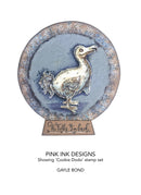 Decorative stamp with a duck design and 'Pink Ink Designs' branding on a white background