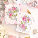 Floral cards with decorative elements on a table with flowers and stationery.