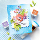 Handmade card with floral design and 'Here for you, always' text, surrounded by stamping tools on a checkered background.