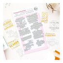 A flat-lay product shot of a stamp and die set called 'Treasured Greetings' by Plaide Studio. The set includes a sheet of silver metal stamp dies on a white backing card with a pink center, surrounded by sample stamped text designs on a white background with decorative gold and white elements.