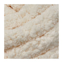 A close-up texture shot of a soft, fluffy faux fur or sherpa fabric in a warm off-white or cream color.
