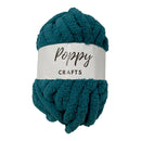 A skein of chunky, plush chenille yarn in a deep teal color, wrapped with a white paper label that reads 'Poppy CRAFTS'.