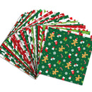A fan arrangement of Christmas-themed wrapping paper sheets on a plain white background. The visible designs include red and green stripes, white snowflakes, gingerbread men, candy canes, stockings, and gift boxes on a dark green base.