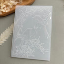 A translucent white silicone mold featuring embossed line art of two birds perched on flowering branches, displayed on a neutral gray surface with dried floral props.