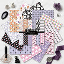 Collection of Halloween-themed scrapbooking paper sheets on a white surface with decorative items.