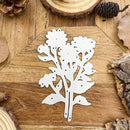 White floral metal cutting board on a wooden surface with natural elements.