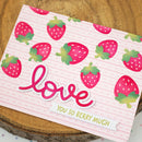 Card with strawberry pattern and 'love you so berry much' text on a wooden surface