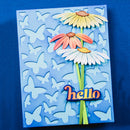 A handmade layered paper card featuring three 3D daisy flowers in yellow, peach, and white with green stems, set against a blue background with cutout butterflies and the word 'hello' in orange and blue at the bottom.