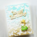 A handmade greeting card featuring a light blue to cream gradient background with layered white butterfly cutouts. The card has a raised gold foil 'happy birthday' text and a 3D mouse character wearing a yellow hat and green outfit at the bottom right.