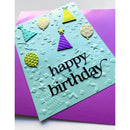 A handmade square birthday card with a light aqua background, embossed party confetti and stars, and the words 'happy birthday' in black script. The card is decorated with colorful paper party hats, balloons, and stars, and is layered over a purple envelope.